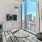 a room with a tv and a table with a window with a city view