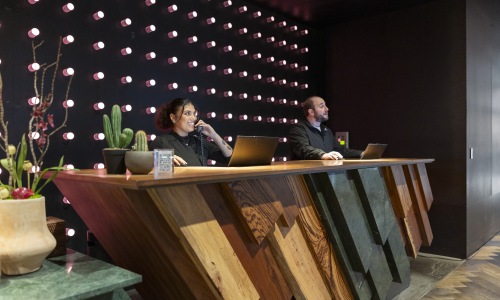 Hotel front desk at Sienna at The Thompson in Austin, Texas featuring a modern geometric reception desk, designer lighting, and a stylish luxury hospitality check-in experience.