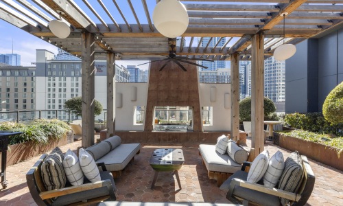 Private outdoor Bayberry Lounge with covered seating, fireplace, and skyline views, an exclusive resident amenity at Sienna at The Thompson in Austin, Texas.