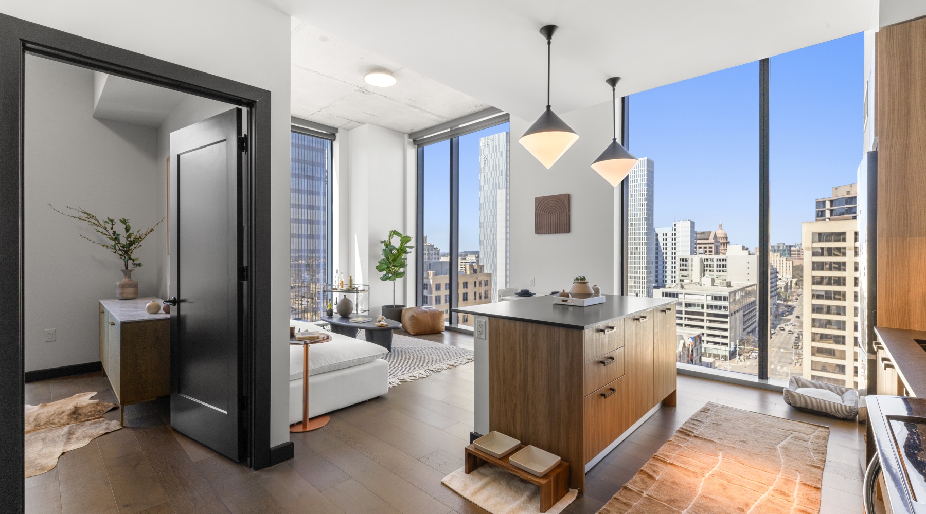 Private balcony at Sienna at the Thompson with glass railing and sweeping downtown Austin skyline views in bright daylight.