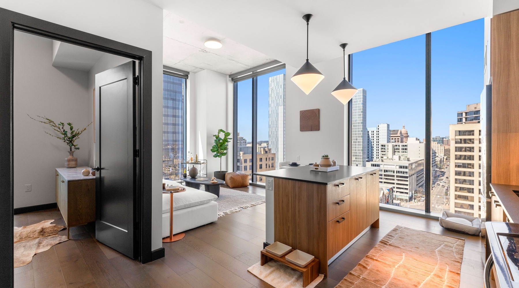 Private balcony at Sienna at the Thompson with glass railing and sweeping downtown Austin skyline views in bright daylight.